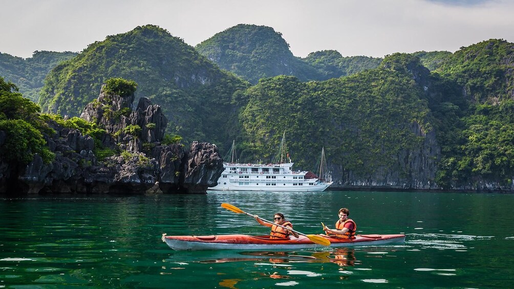 Kayak and boat on reflective Halong Bay in Vietnam