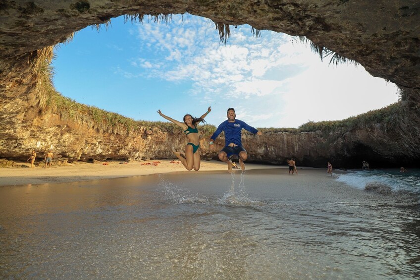 couple leaps for photo opp in water cave