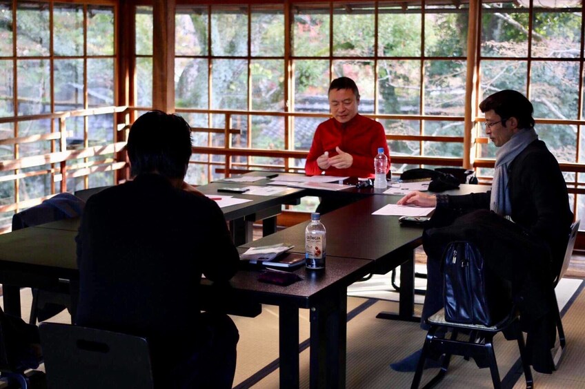 Men sit to write haikus in Kyoto