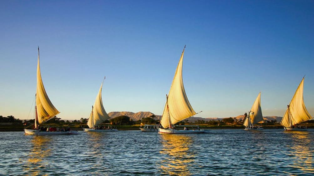 Sailboats and their reflections on the Nile in Egypt