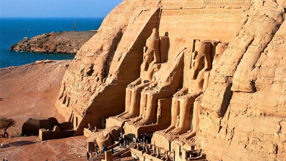 Statues carved into Abu Simbel Temples with view of water