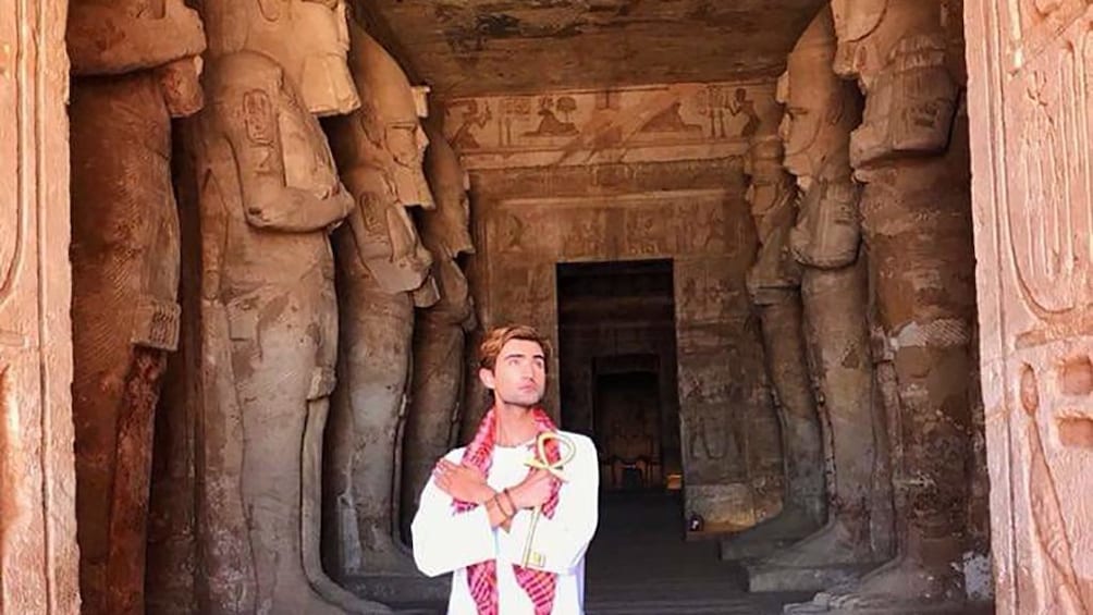 Man poses in threshold of Abu Simbel Temples in Aswan, Egypt