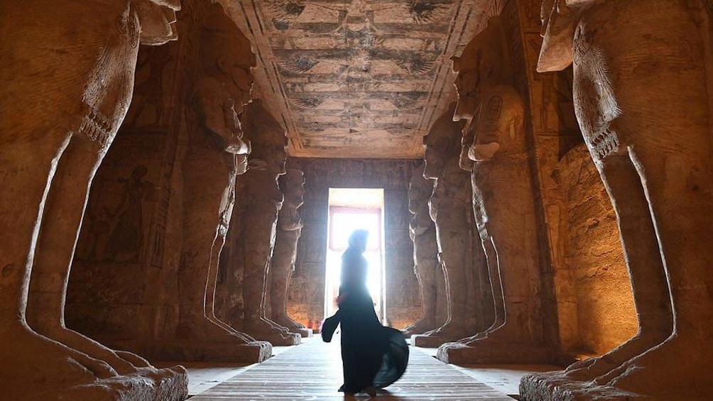 Person stands between large statues inside Abu Simbel Temples