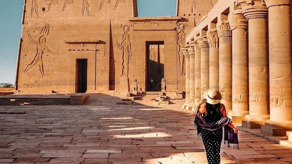 Woman stands in front of Philae Temple in Egypt