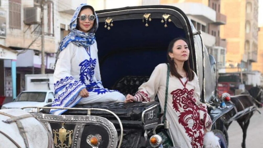 Two women pose on carriage in Aswan, Egypt