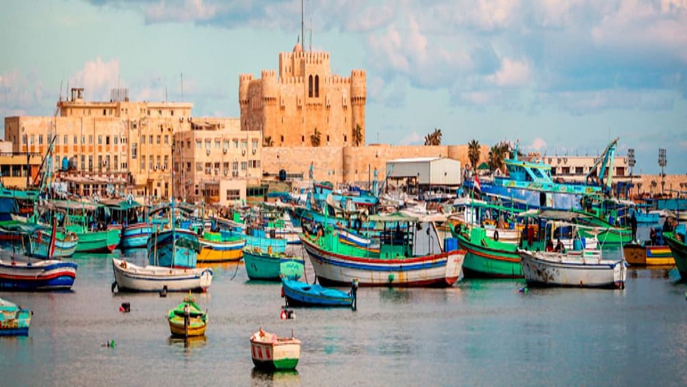 Painting of colorful boats in the Mediterranean Sea with Citadel of Qaitbay in the background