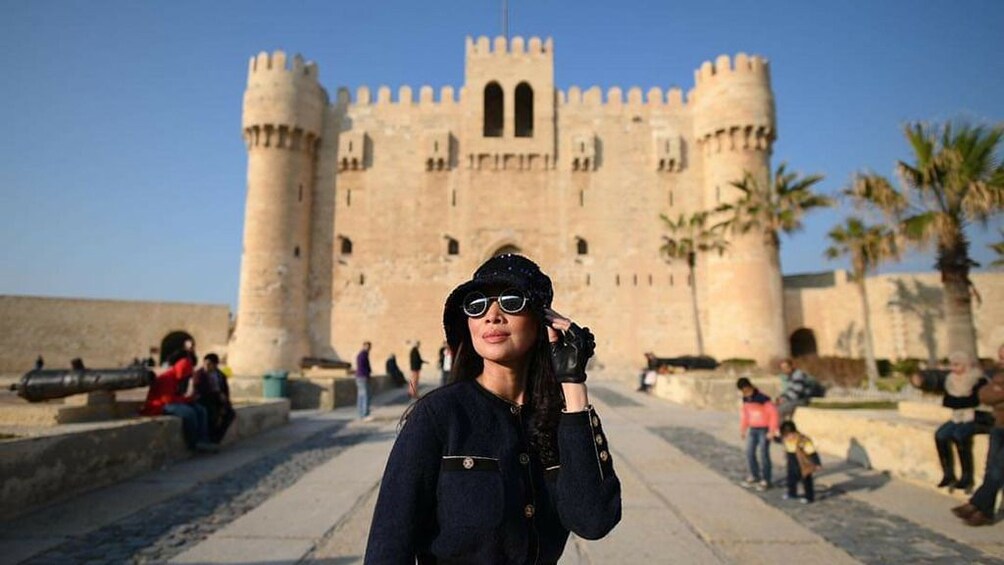 Woman with hat and in front of the Citadel of Qaitbay in Alexandria, Egypt