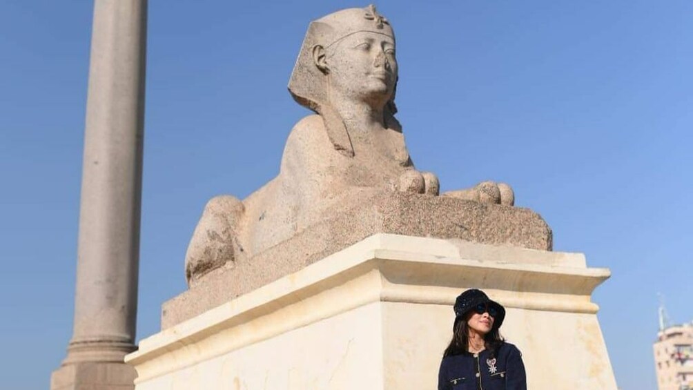 Woman poses in front of sphynx in Alexandria, Egypt