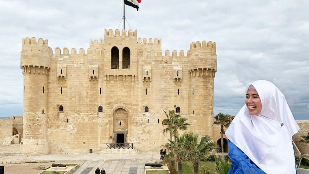 Woman smiles in front of the Citadel of Qaitbay
