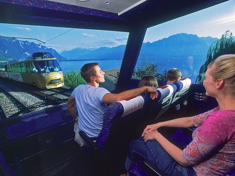 Guests aboard the Golden Express train overlooking the Alps