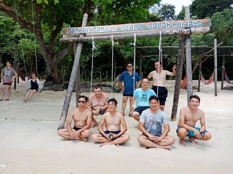 Group sitting on the sand on Pandan Pandan Island

