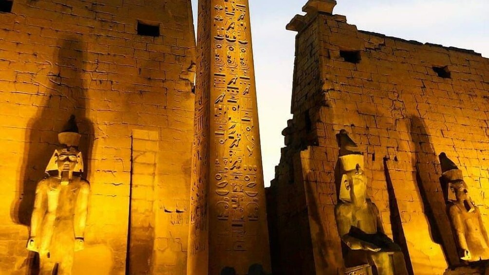 Illuminated Egyptian temple with hieroglyphics and pharaoh statues