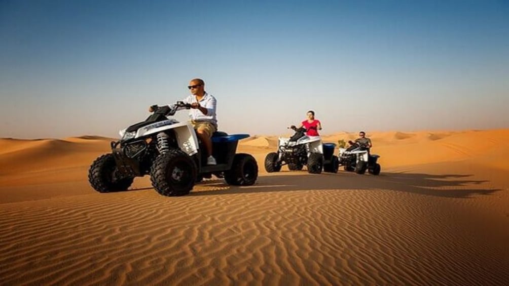 Tourists ride quad bikes through Sahara Desert