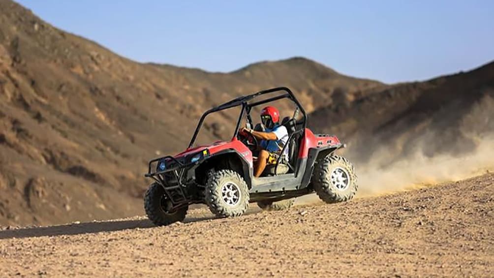 Man drives dune buggy down hill in Hurghada Desert