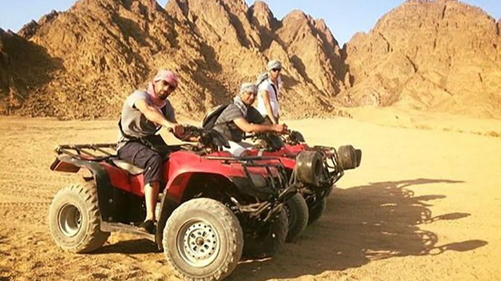 Tourists pose on dune buggies in Hurghada Desert in Egypt