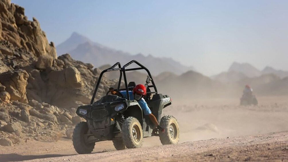 Man drives dune buggy through dusty Hurghada Desert