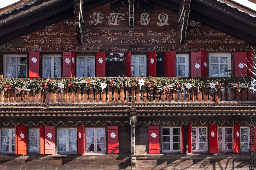 Closeup of large wood home with red shutters in Switzerland