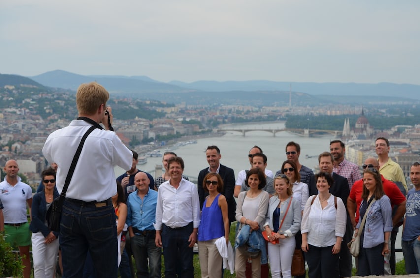 Guide takes photo of group in front of panoramic view of Budapest, Hungary