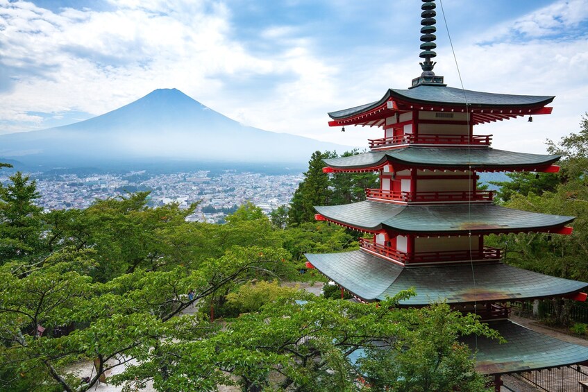 Pagoda surrounded by trees with Mount Fuji in the background