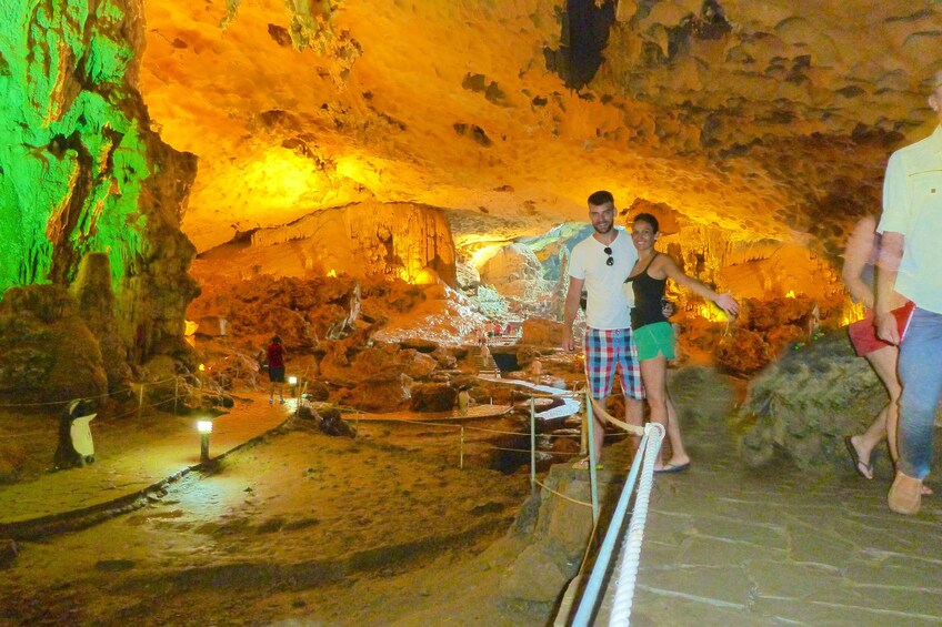 Couple pose in lit up Thien Cung Grotto in Halong Bay, Vietnam