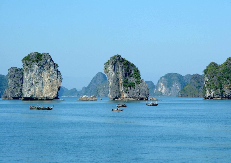 Small boats sail around islands of Halong Bay