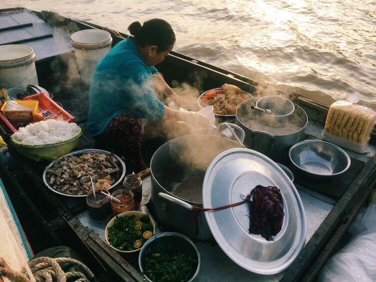 Woman preparing food to sell at the Mekong Delta Floating Market
