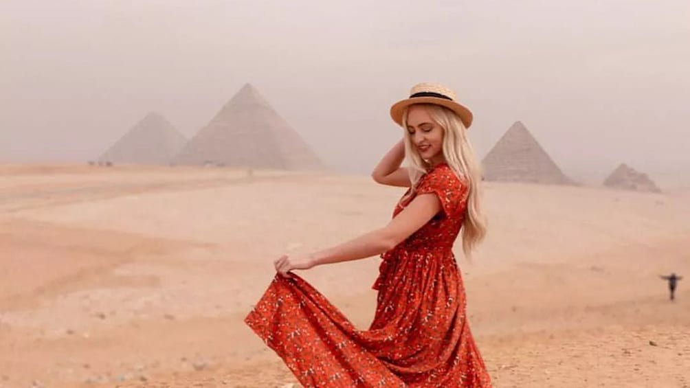 Woman hat poses in front of the Great Pyramids