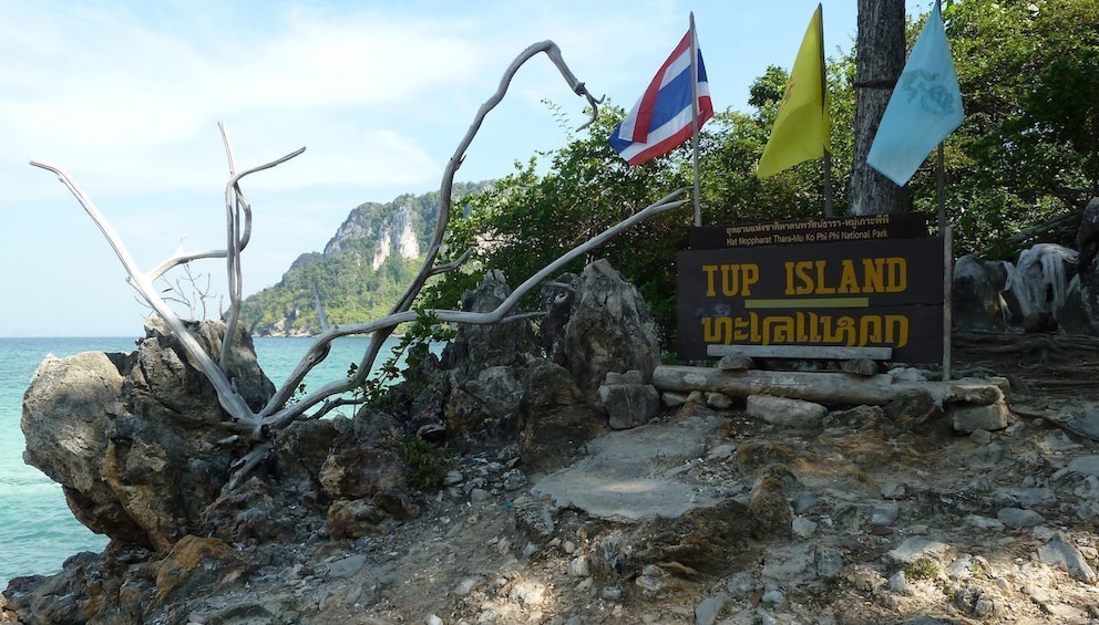 Sign for Tup Island with three flags mounted on it