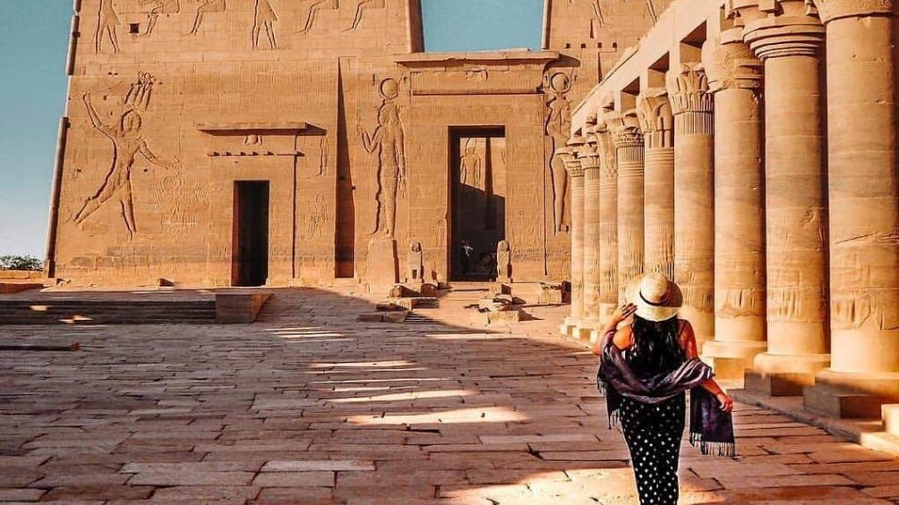 Woman walks along grounds of Philae Temple in Aswan, Egypt