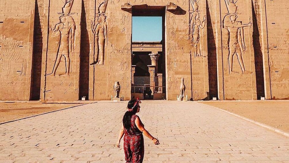 Woman poses in front of the Temple of Horus at Edfu
