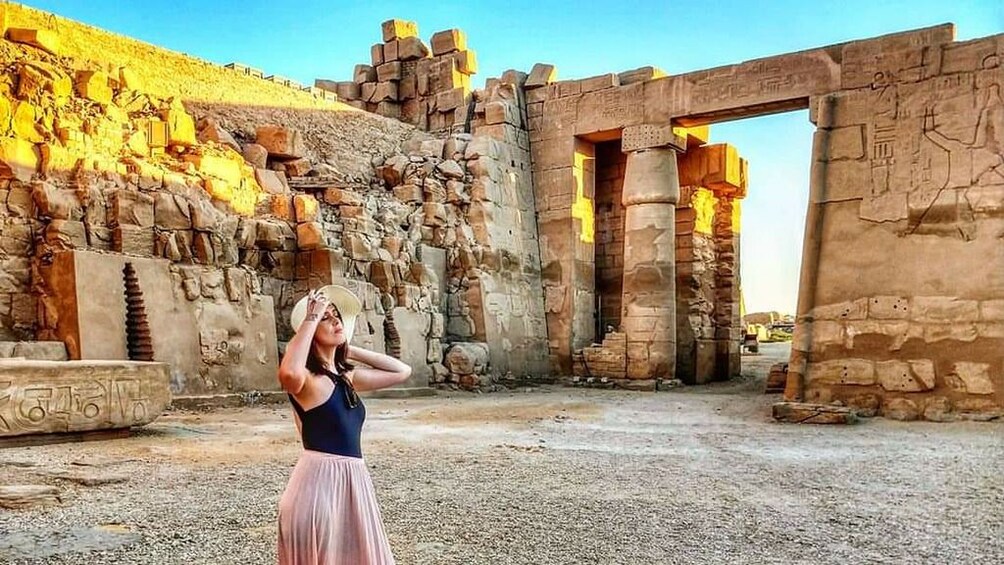 Woman poses in front of temple ruins in Egypt