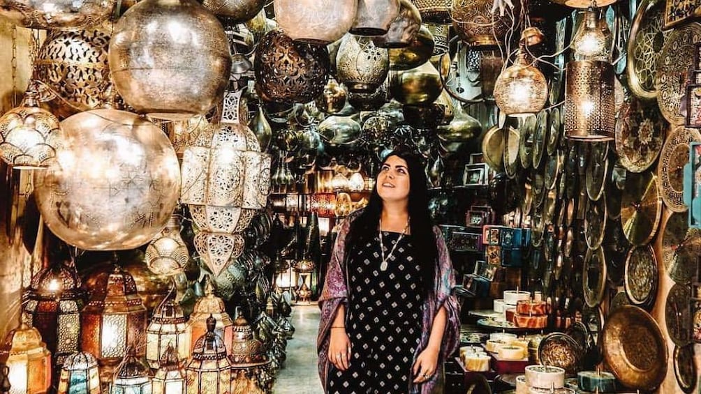 Woman surrounded by metal lanterns in Khan El Khalili market