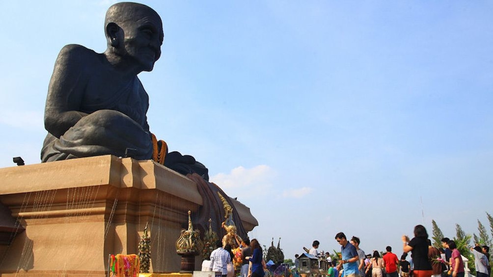 Tourists observe statue at Wat Huay Mongkol Temple