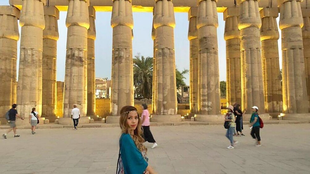 Woman poses in front of group of ancient Egyptian columns