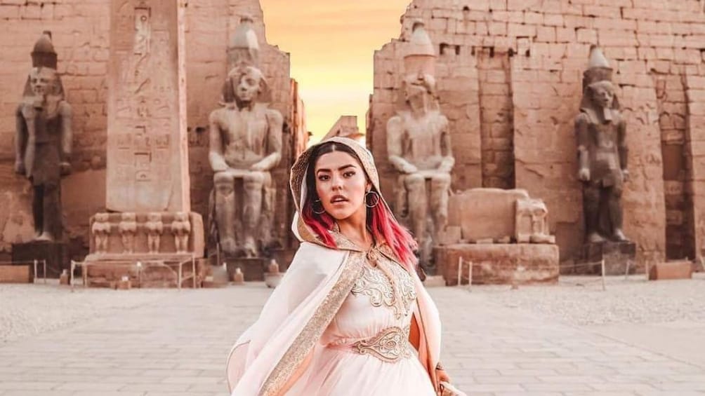 Woman in dress poses in front of Luxor Temple in Egypt