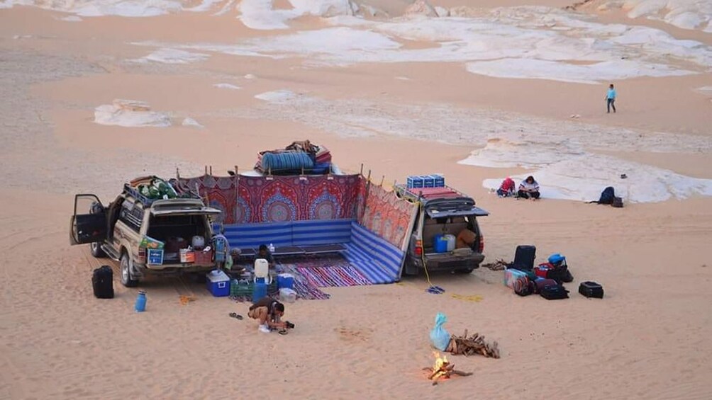 Two cars and tapestries make small camp in the Egyptian desert