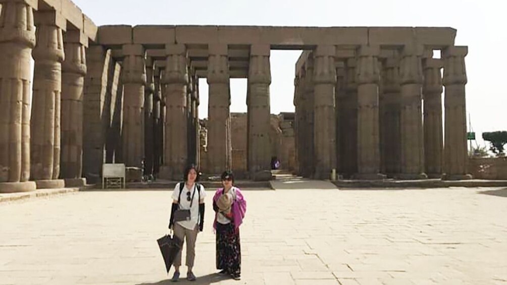 Tourists pose in front of the columns of Luxor Temple in Egypt
