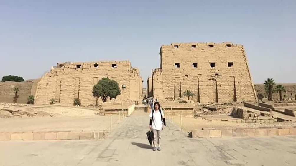 Tourist poses in front of Karnak in Luxor, Egypt