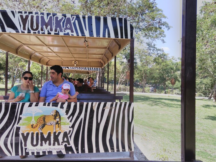 Parents and child on tram in Yumka Reserve in Tabasco, Mexico