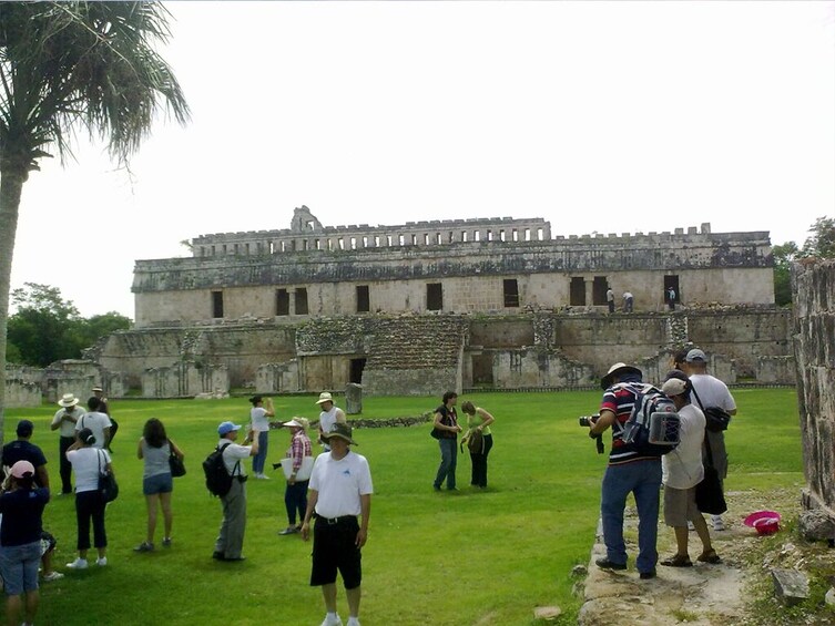 Tourists survey ruins at Kabah site in Uxmal, Mexico