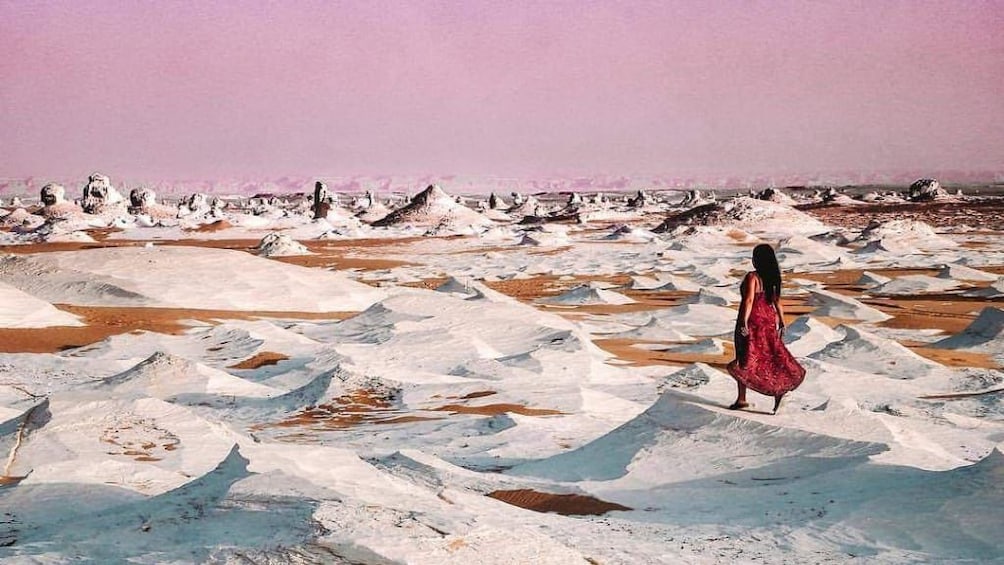 Panoramic view of White Desert and small sand dunes with woman standing to the side