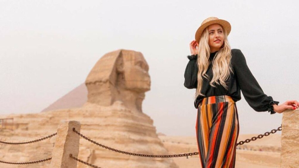 Woman poses with Sphinx of Giza in the background