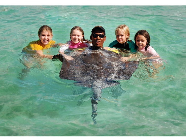 Guide and group of kids pose with stingray in Punta Cana