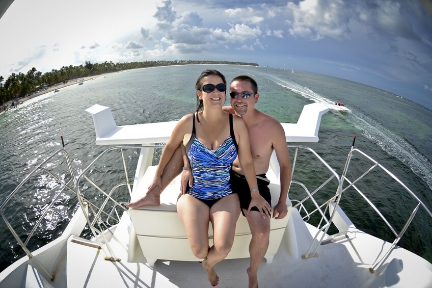 Couple in swimsuits pose on back of boat in Punta Cana