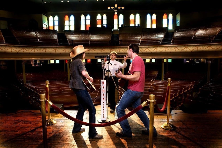 Show item 3 of 6. Tourists onstage at Ryman Auditorium in Nashville