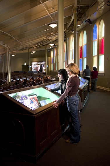 Show item 4 of 6. Women looking at artifacts at the Ryman Auditorium in Nashville