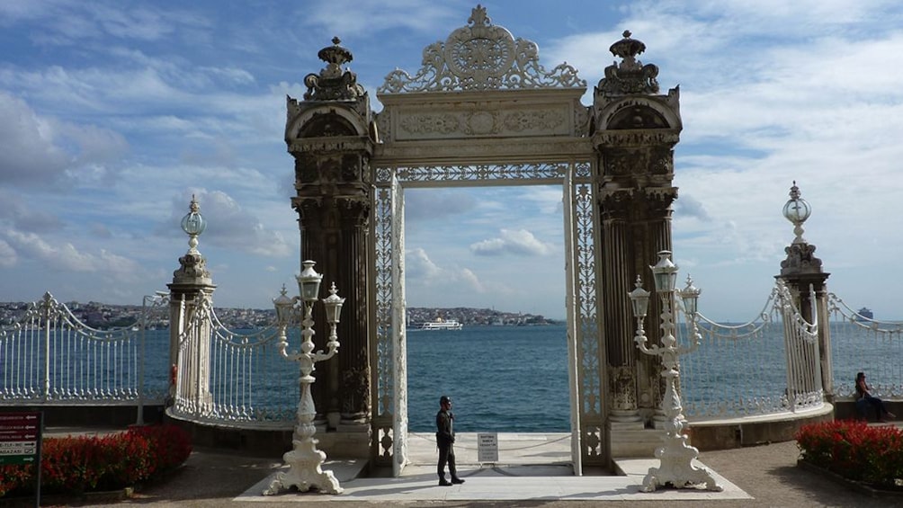 Show item 5 of 4. Large entry gate at Dolmabahçe Palace with view of water