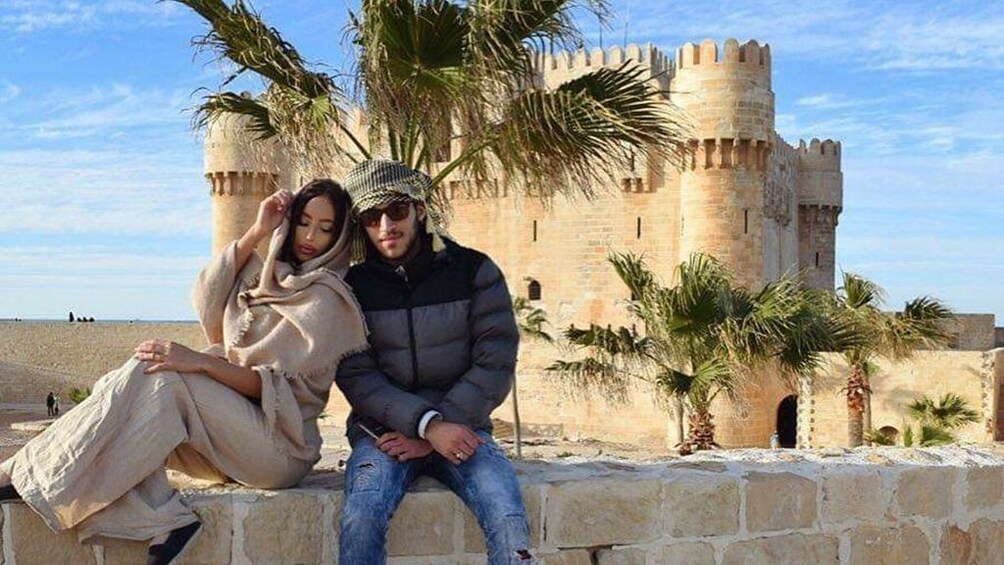 Couple sits in front of temple in Egypt