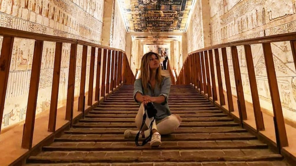 Woman sits of steps inside Egyptian temple