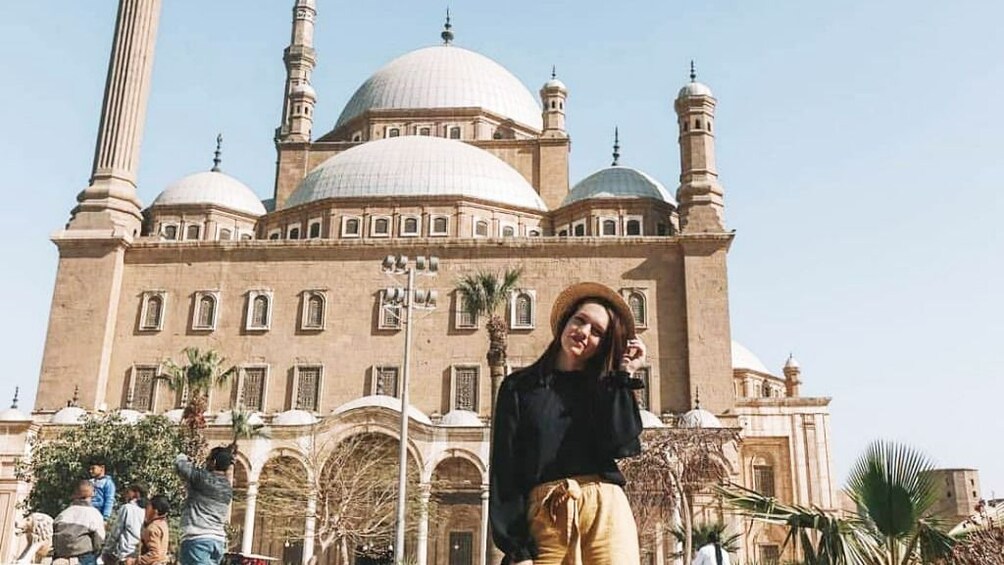 Woman with hat poses in front of Mosque of Muhammad Ali in Cairo, Egypt